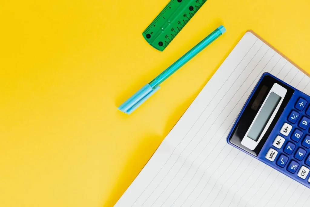Fournitures scolaires sur fond jaune pour préparer le budget de rentrée